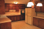 Kitchen with stained cabinets and tile counters. no image
