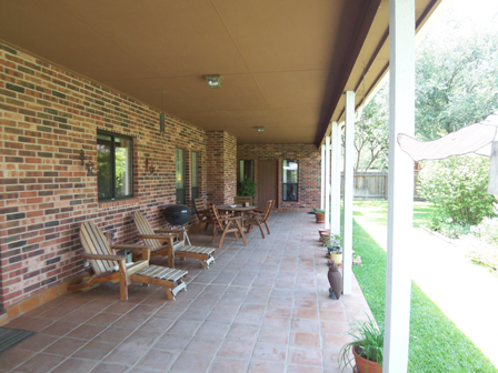 A covered porch looking out over your lush lawn at 1618 Wood Quail in San Antonio Texas
